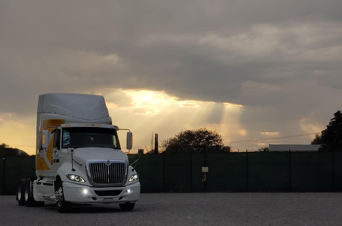 Tracto Loreto Trucking bajo cielo al atardecer